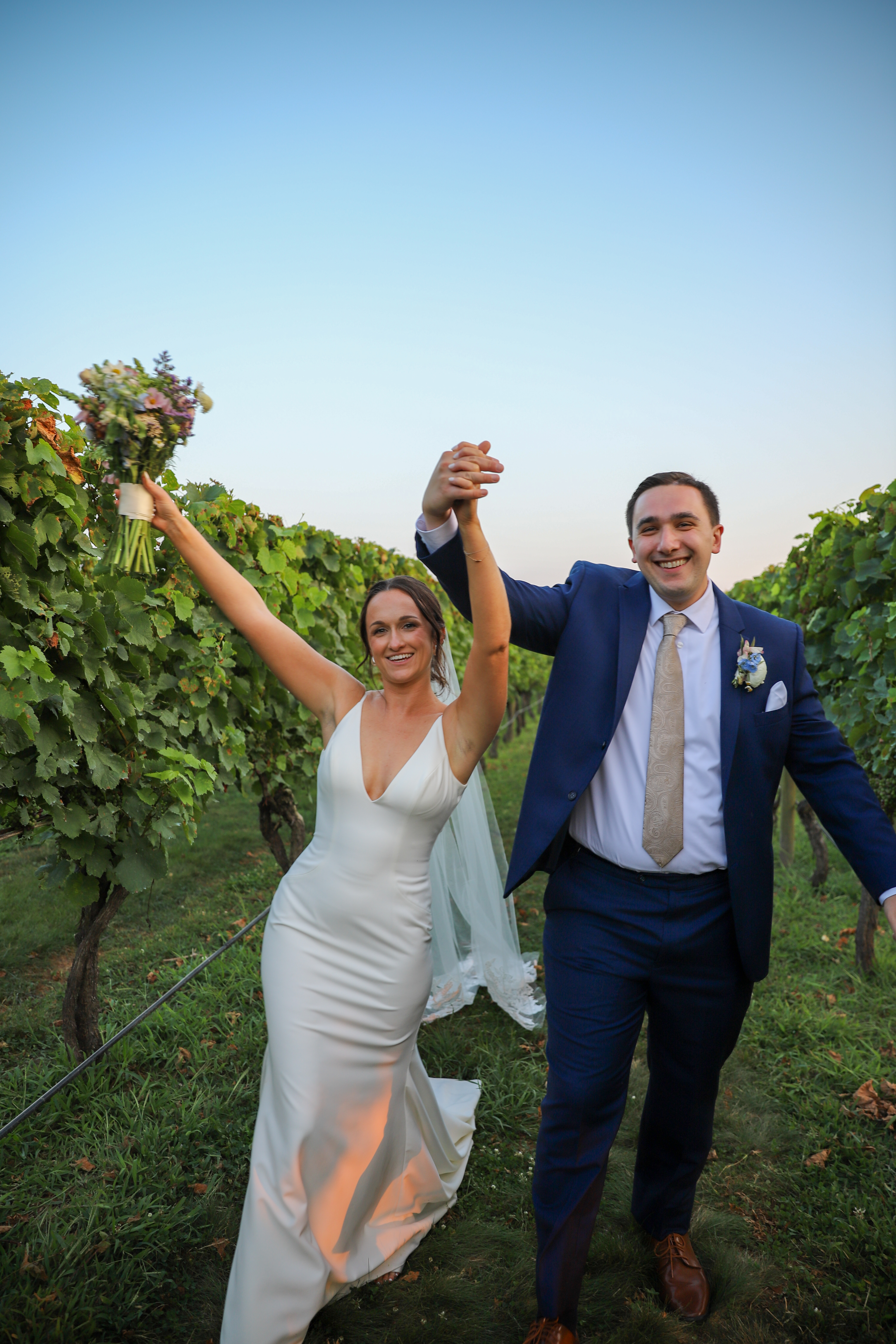 Couple celebrating in vineyard setting.